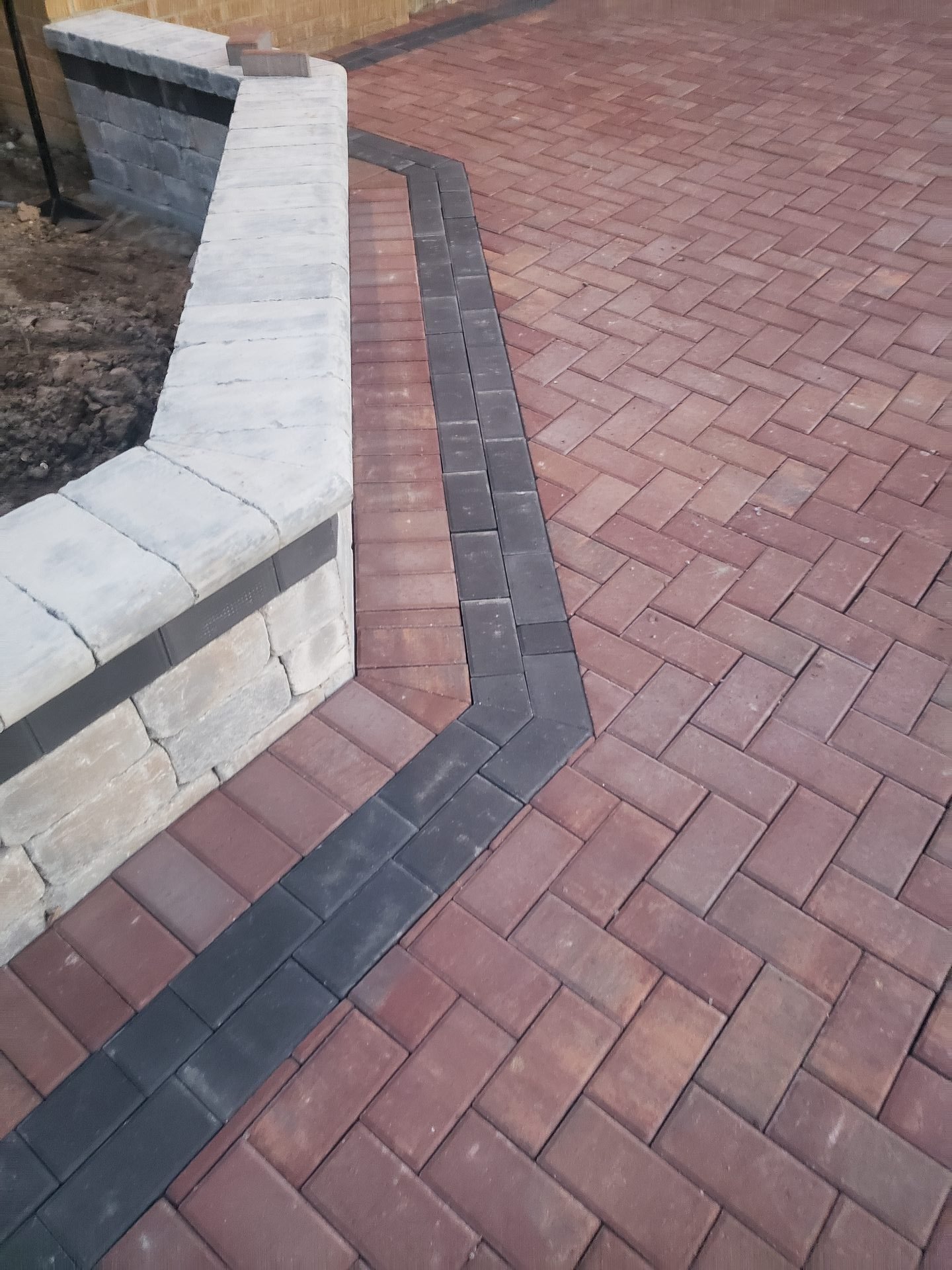 Burgundy herringbone brick paver patio with charcoal border and stone steps