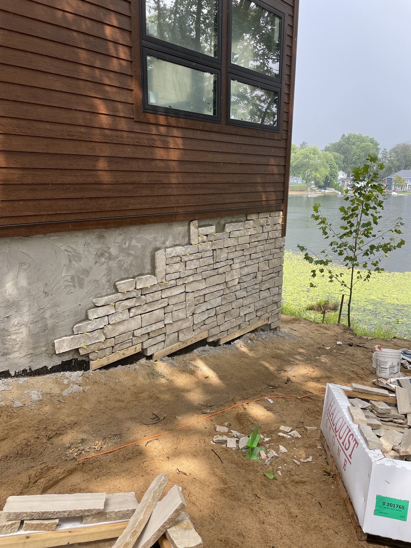 Natural stone retaining wall installation with lake view