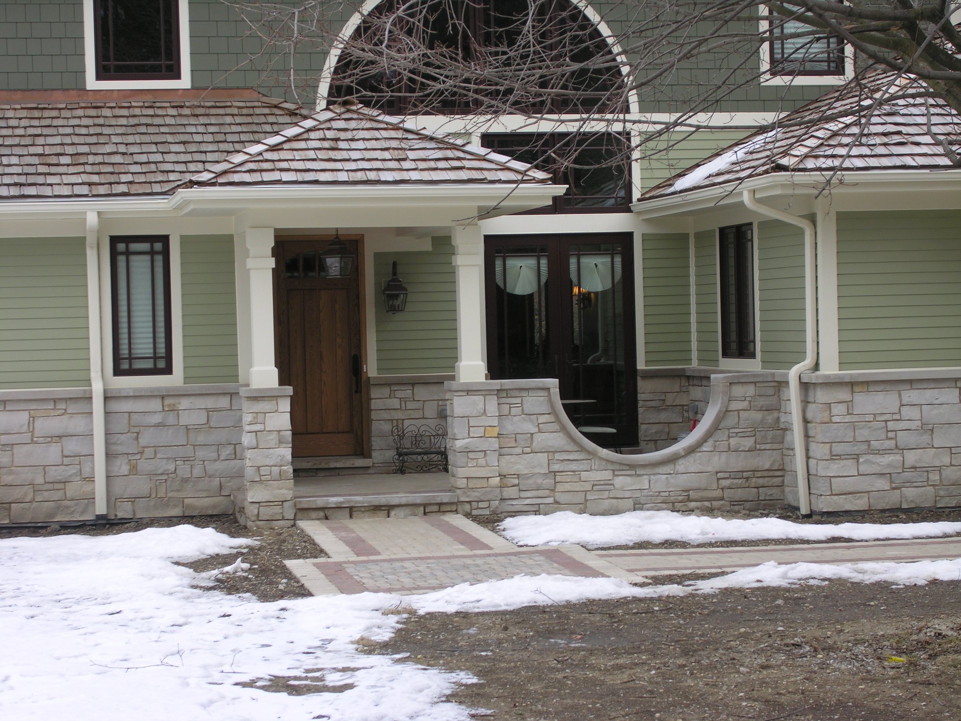 Entry porch with stone base, cedar shakes, and paver walkway
