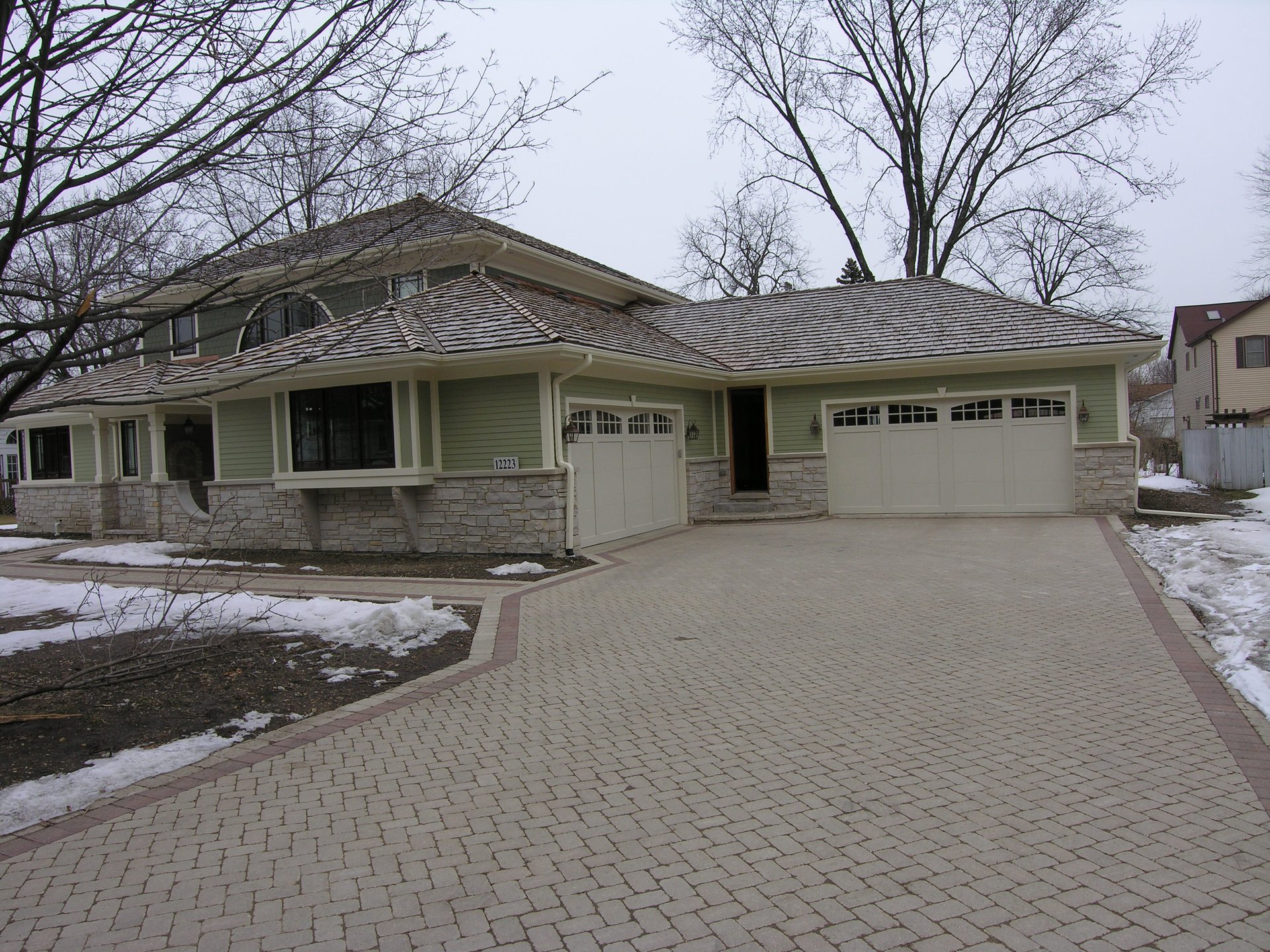 Zeiler Construction custom home in Palos Heights with paver driveway and stone base