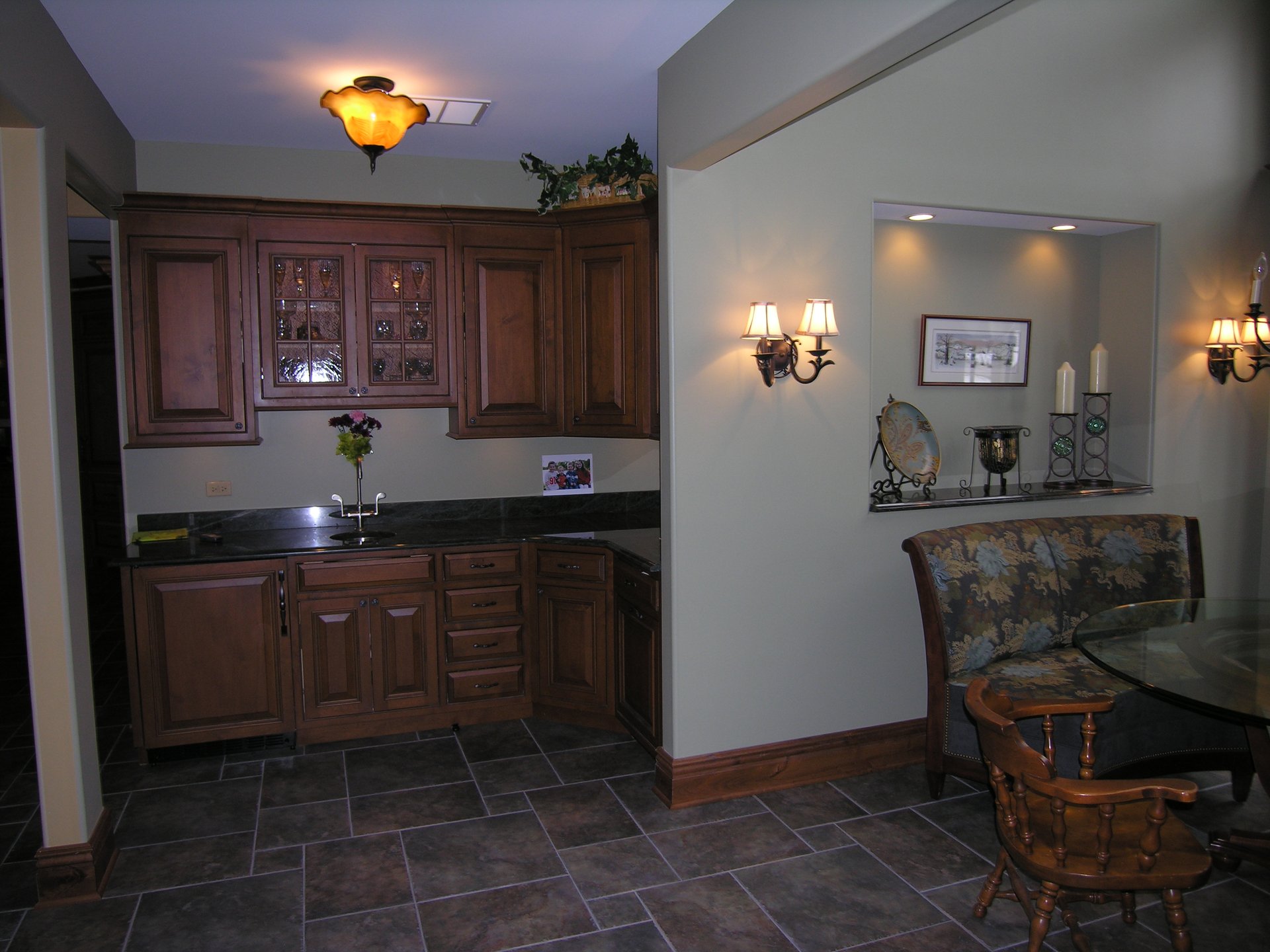 Custom wet bar with granite counter and glass-front cabinets