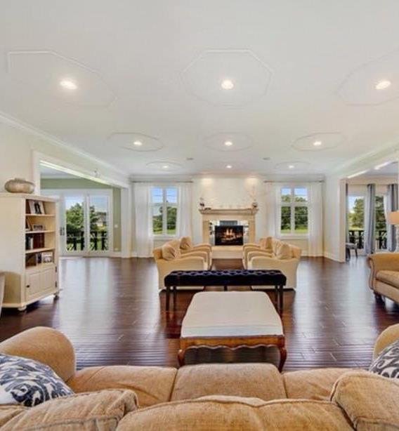 Great room with formal fireplace, coffered ceiling, and hardwood floors
