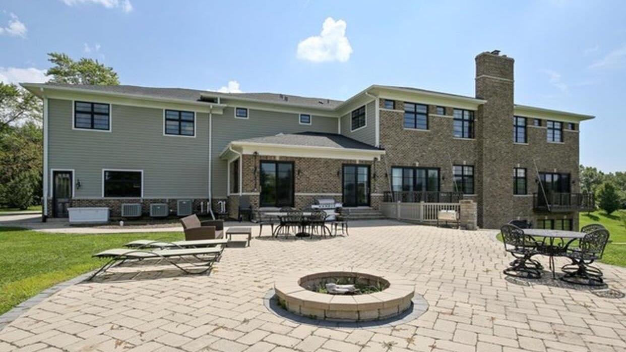 Rear exterior with paver patio and stone fire pit on a Zeiler Construction custom home